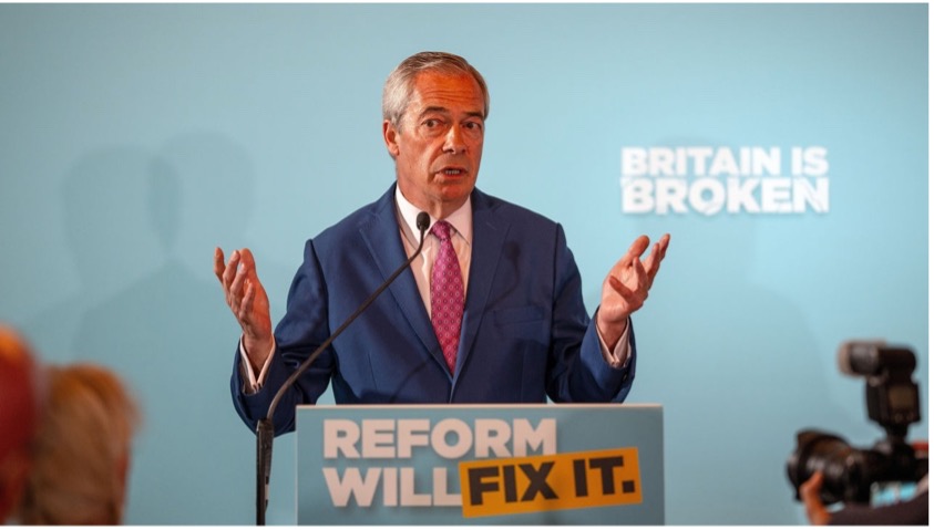 A person in a suit standing at a podium.